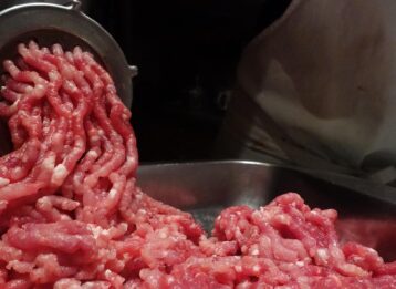 Hackfleisch wird durch den Fleischwolf gedreht.
