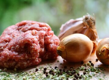 Hackfleisch mit Zwiebel auf Holzbrett.