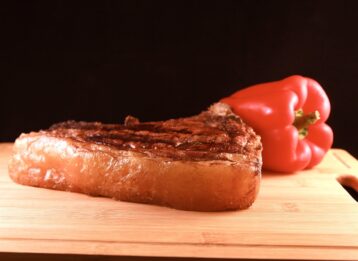 Steak auf Holzbrett mit Paprika.