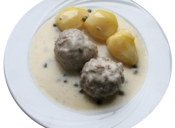 Königsberger Klopse mit Kartoffeln auf Teller.