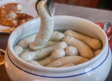 Was ist Weißwurst, woher kommt sie und wie isst man sie richtig? Alles zu Inhalt, Weißwurstfrühstück, Zuzeln und schlesischer Weißwurst.
